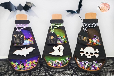 Three Halloween potion bottle shaker signs in different style. One purple "bat wings", one green "ghost tears", and one black "poison".