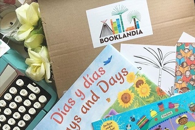 A book subscription box with a Booklandia logo, a few books and a typewriter.