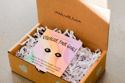 An Earspiration of the Month subscription box with a card in it that says visualize your goals.