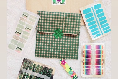 Items from a Nail Shack subscription box including shamrock, blue and rainbow nail stick ons.