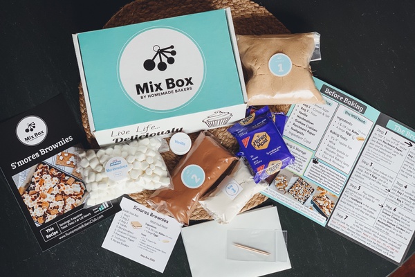 A Mix Box surrounded by various baking mixes, a bag of marshmallows and a few recipe cards.