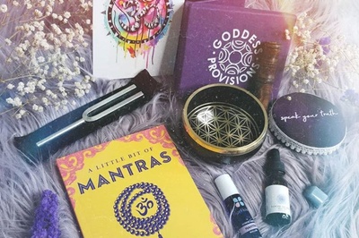Items from a Goddess Provisions subscription box including a tuning fork, a book of mantras, essential oils and more.