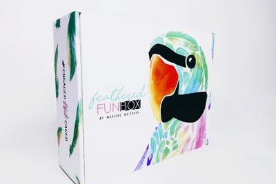 A closed Feathered Fun subscription box with a parrot on it.