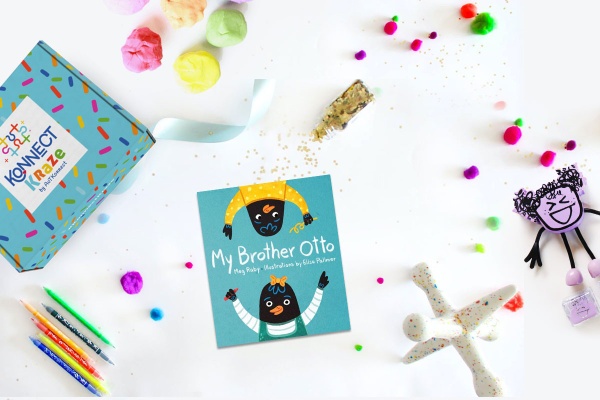 A colorful Konnect Kraze subscription box next to a book titled My Brother Otto, pencils, play dough and other toys.