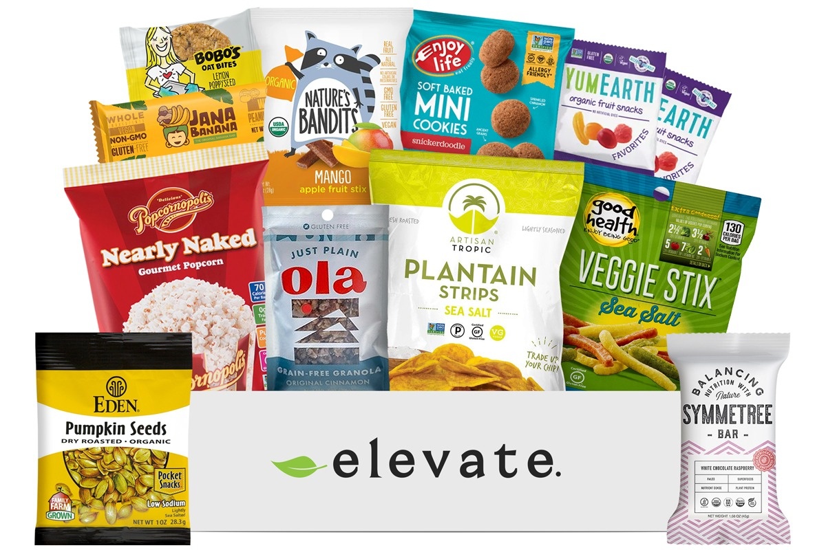 An Elevate Snack subscription box filled with pumpkin seeds, popcorn, veggies sticks, mini cookies and more.