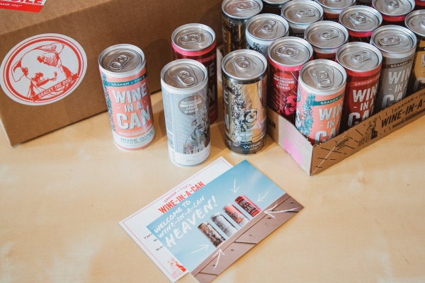 A bunch of cans with the label Wine in a Can and a card that says Welcome to Wine in a can heaven.