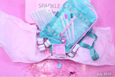 Items from Sparkle & Co. Luxe Nails subscription box, including nail polish, nail color samples, a bag and more.