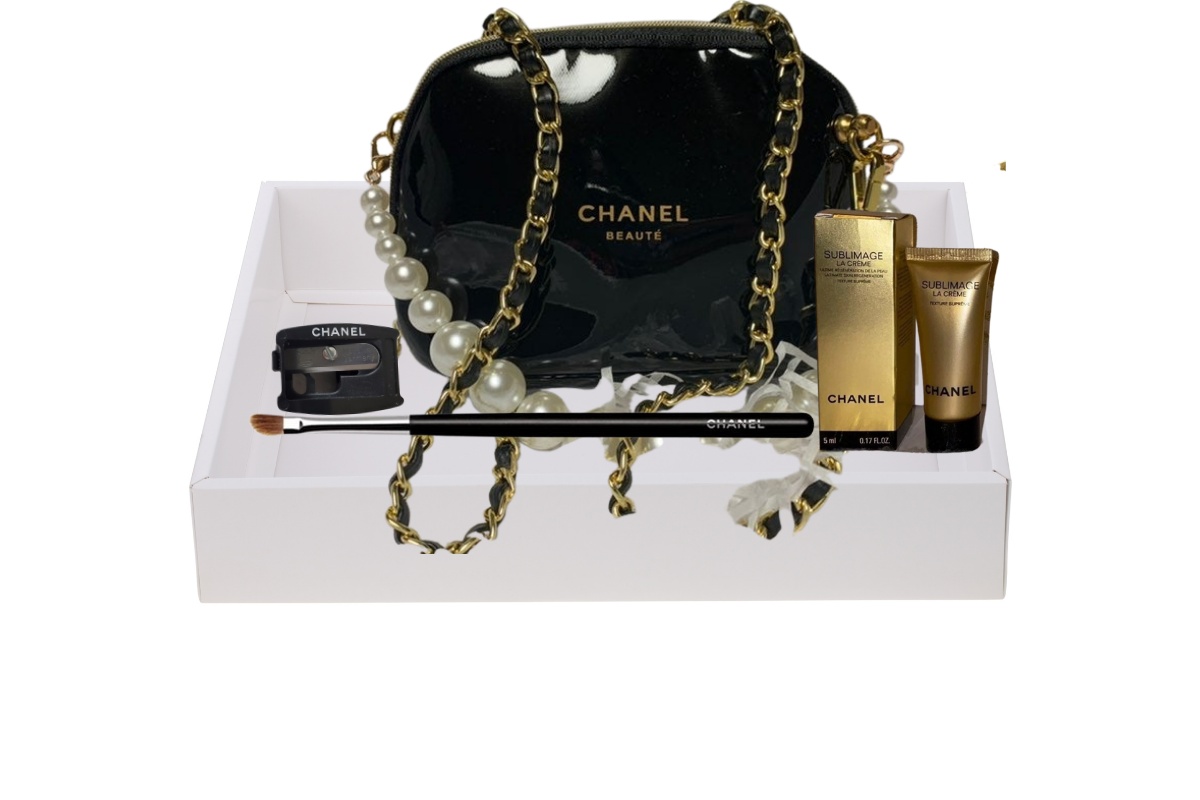 A white tray filled with a black Chanel purse, a makeup brush, and other makeup products.