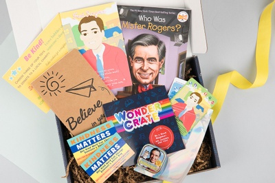An open Wonder Crate subscription box filled with books and cards.