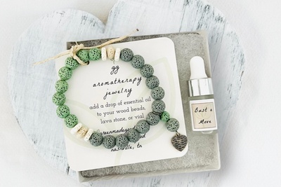 Green Lava Diffuser Bracelet with Heart Charm in White Gift Box with Aromatherapy Instruction Card and Bust a Move Mini Oil Dropper.