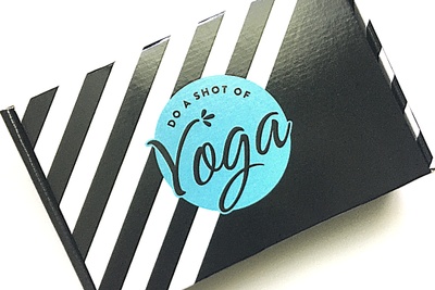 A black and white striped Do a Shot of Yoga subscription box.