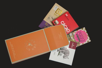 Items from a Bar and Cocoa subscription box, including a cacao bar and other types of chocolate.