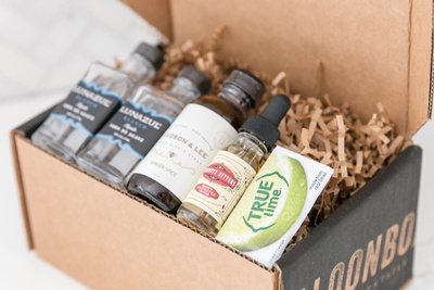 A SaloonBox DIY Cocktail Kit subscription box filled with various bitters and liquors.