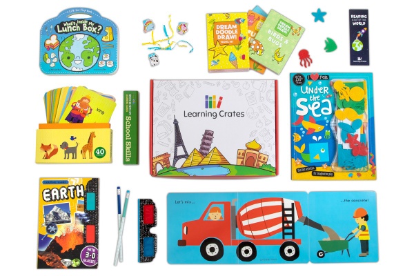 A Learning Crates subscription box surrounded by children's books, 3D glasses, and 2 pencils.