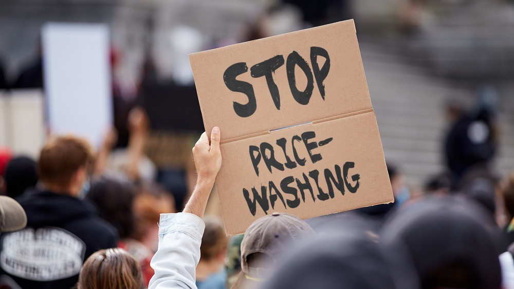 Person holding up a protest sign calling for an end to pricewashing