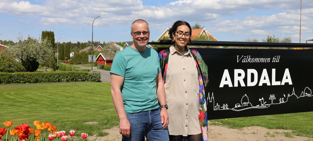 En man och en kvinna står framför välkomstskylten i Ardala