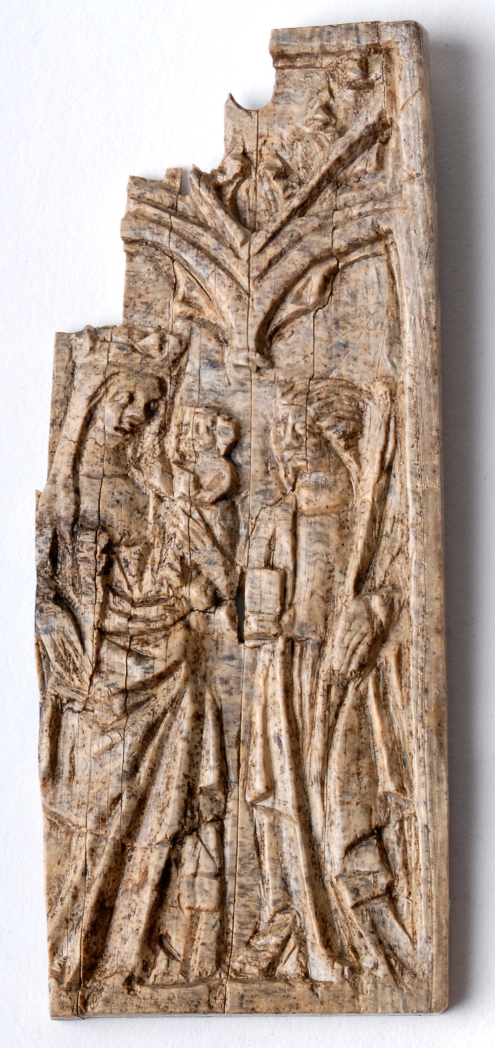 Maria med Jesusbarnet står till vänster och till höger står en mansperson som har en stav i ena handen och någon form av föremål i den andra. Möjligen är det en av ”de vise männen”. Den utskurna reliefen är egentligen baksidan på skrivtavlaFramgrävd i kvarteret Sankt Mikael i Lund år 2019. n. Framsidan hade en yta av vax där man ristade in text. 