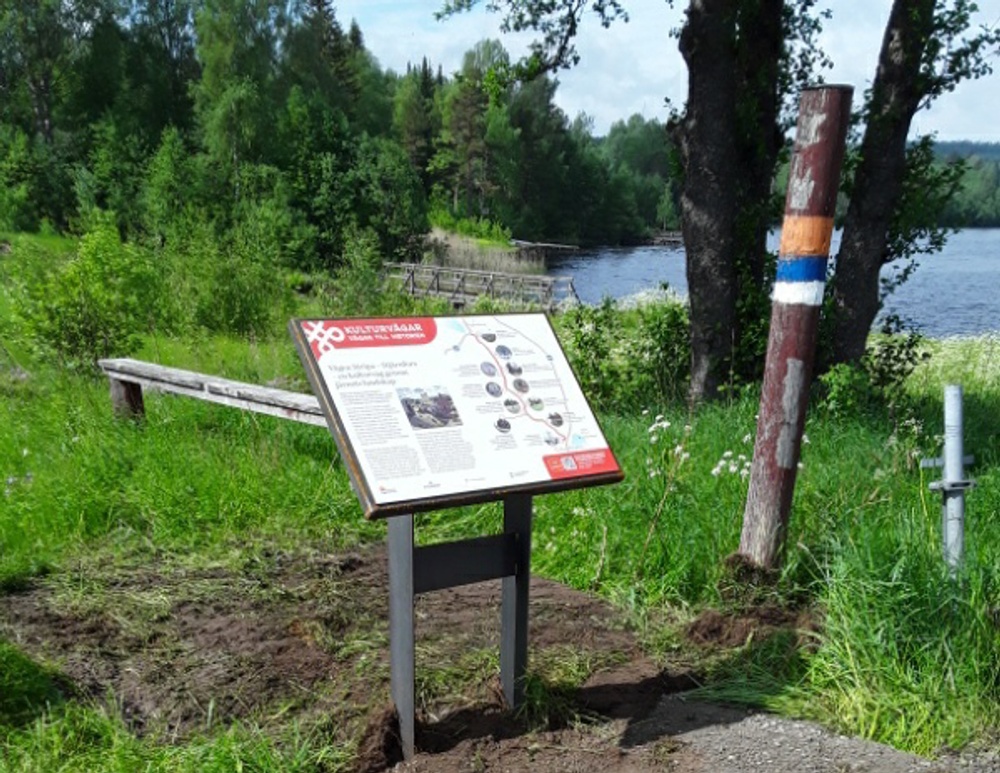 Informationsskylt som står vid sjö.