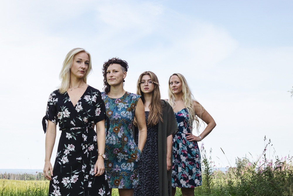 Bild på gruppen Kongero. Från vänster: Anna Wikenius, Lotta Andersson, Sofia Hultqvist Kott och Emma Björling. Personerna står i somrigt åkerlandskap. Foto: Linda Roos.