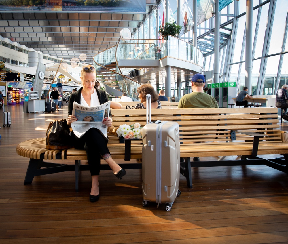Arlanda_Terminalen_passagerare_kvinna med resväska läser tidningen_Anna-Maria Blomqvist.jpg