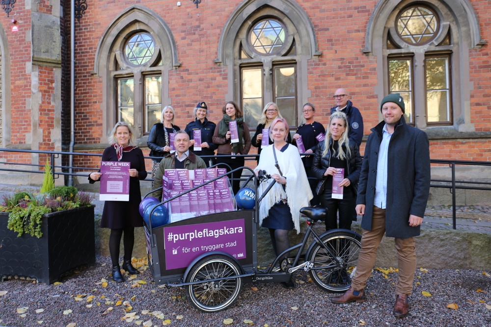 Arbetsgruppen för Purple Flag samlad kring en cykel som kommer att användas under Purple Week.
