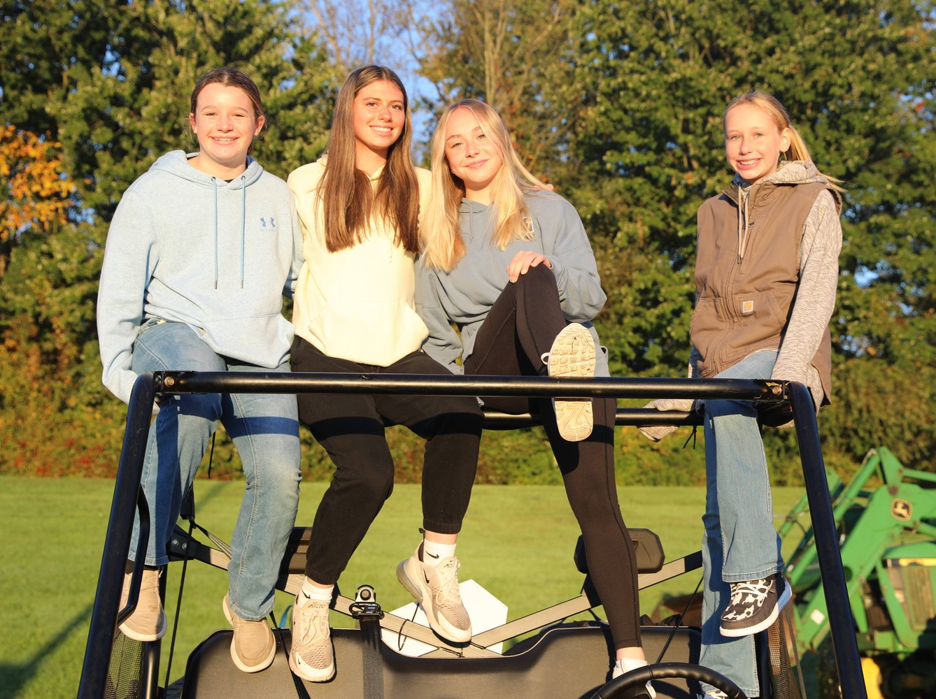 Four students pose in a four-wheeler