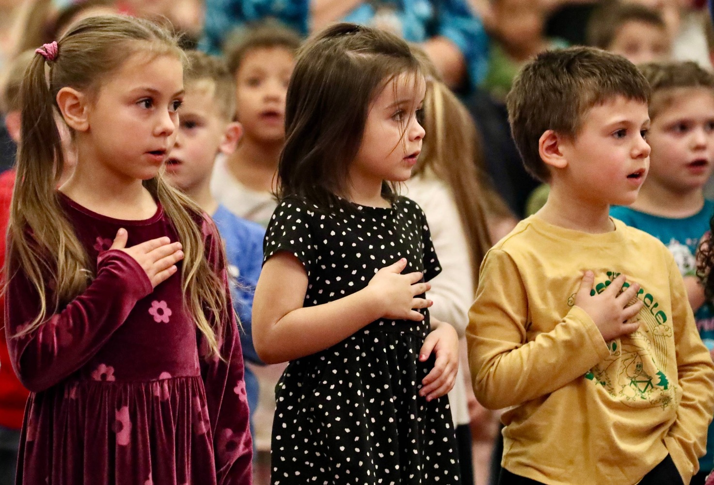 Students stand for the Pledge of Allegiance 