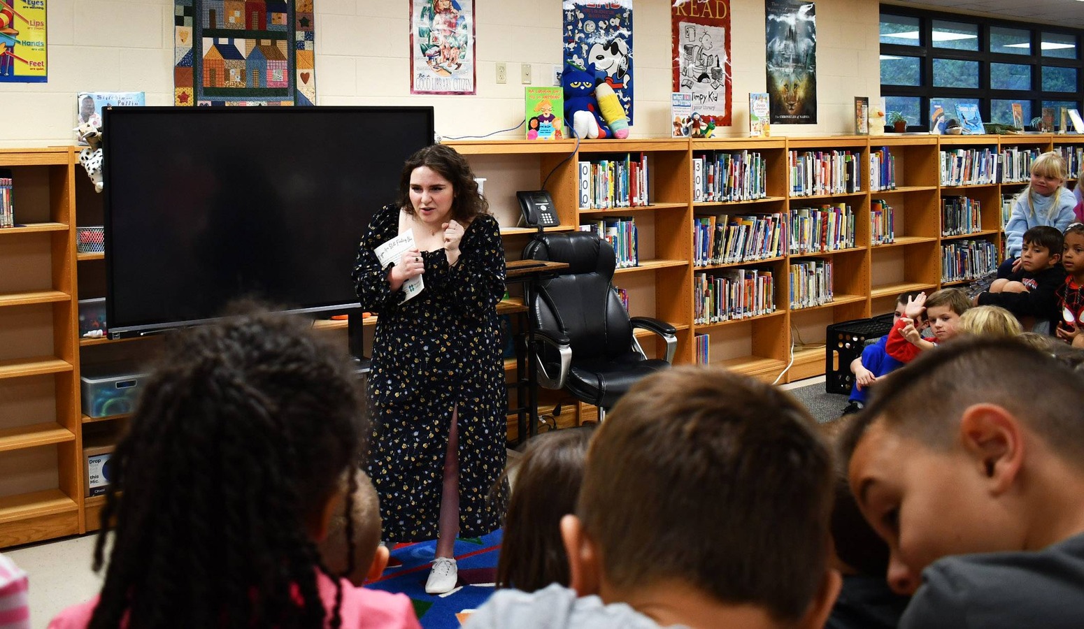 Author speaks to children seated in semicircle