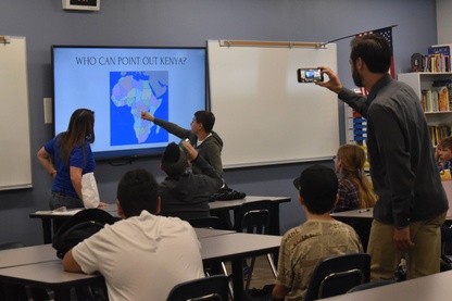 Classroom with presenters pointing out Kenya on a map of Africa