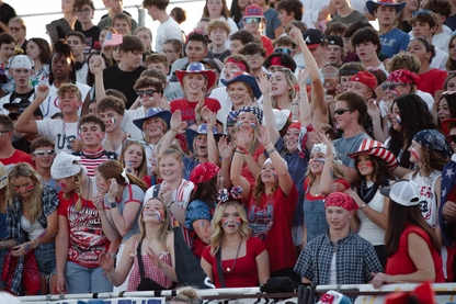 student fans dressed in red white and blue at a football game