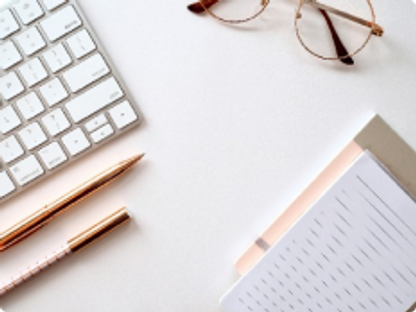 Desk with keyboard, eye glasses, and note pad