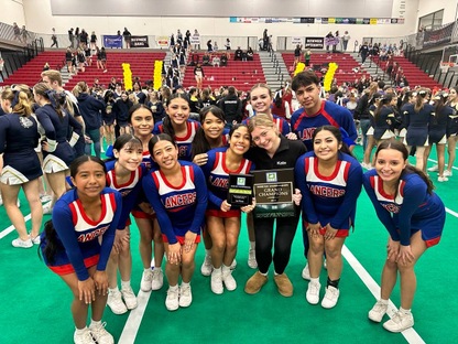 Photo of the Churchill Cheer Team smiling with their 1st-place trophy. 