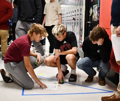 3 students on floor with triangle