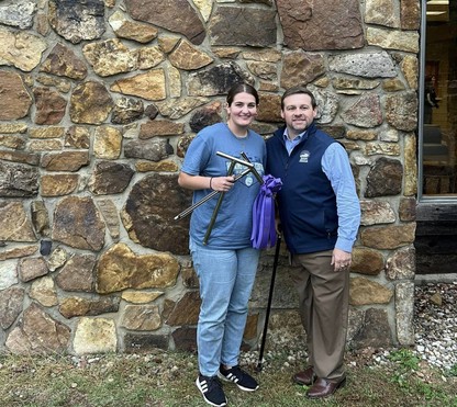 2 people stand in front of rock wall with ribbon