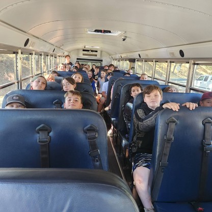 Junior high students sit in a school bus