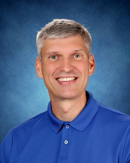 Steve Coram on blue background with blue shirt