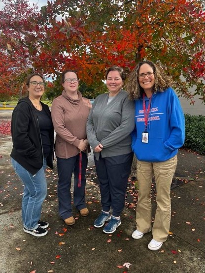 A picture of Churchill's School Counselors standing in front of a tree with leaves turning red in the fall.