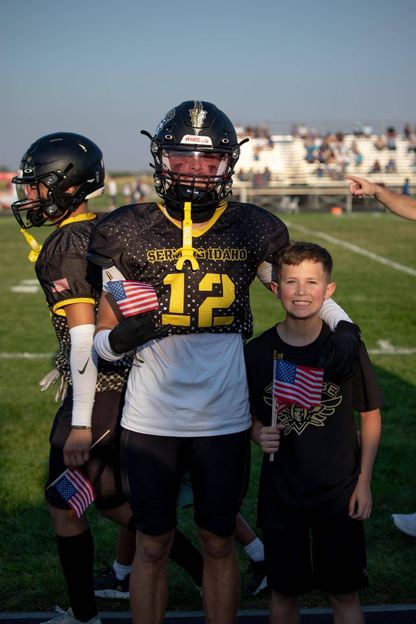 high school football player with his elementary school mentee