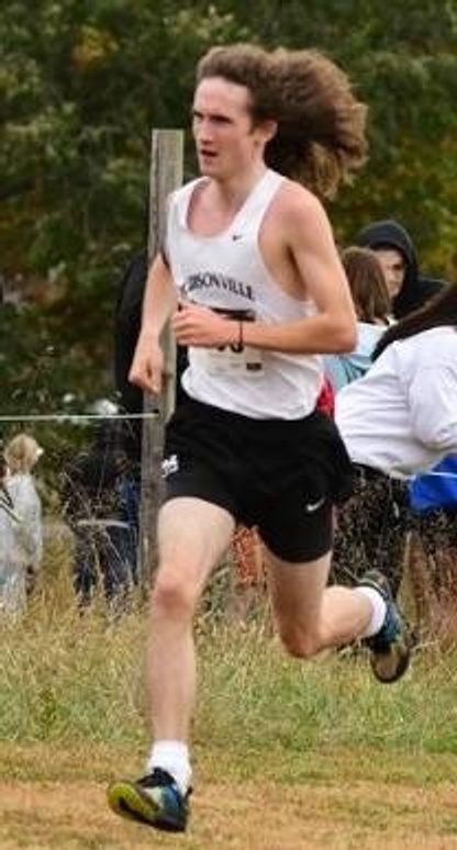 1 person running wearing maroon and white uniform with the word "Madisonville" on the front.