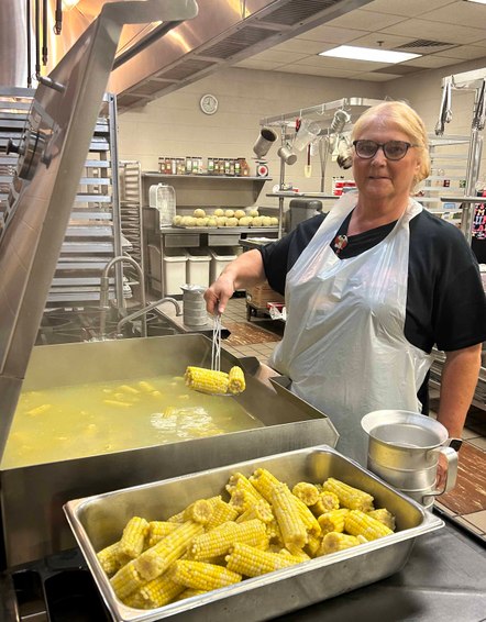 person cooks corn