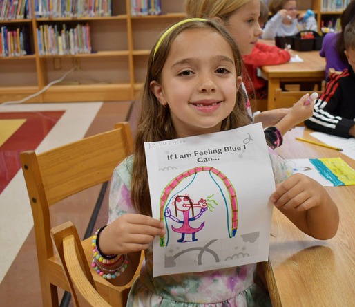 Child holds up drawing