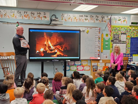 A teacher reads a book titled "Snowy Nap" to a group of children in a classroom.