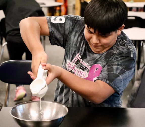 A student makes snacks at mini camp