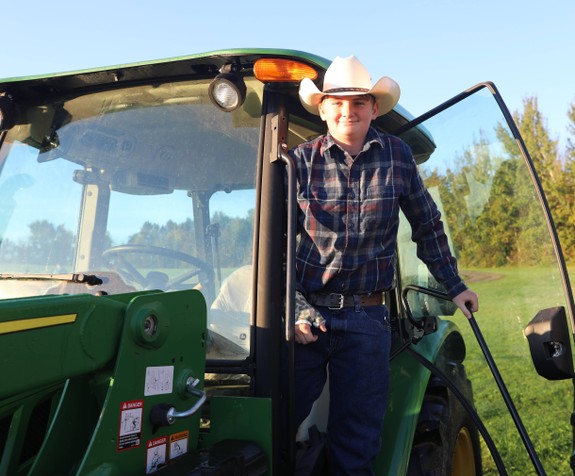 A student exits the tractor cab after driving to school