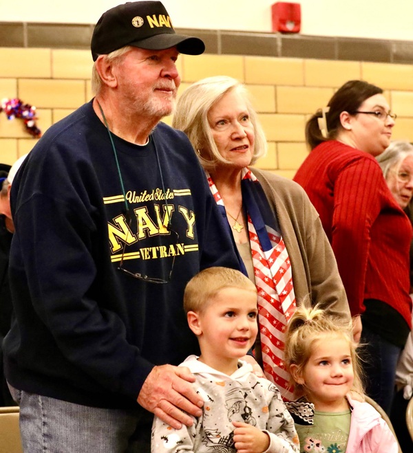 A veteran stands with students 