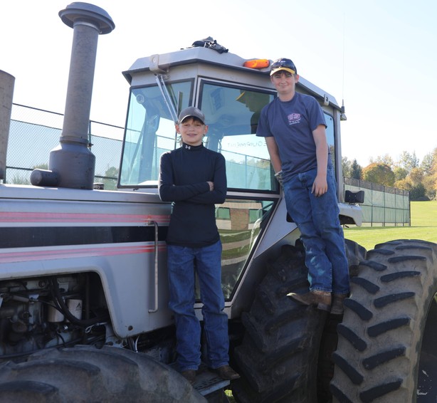 Students stand on a tractor