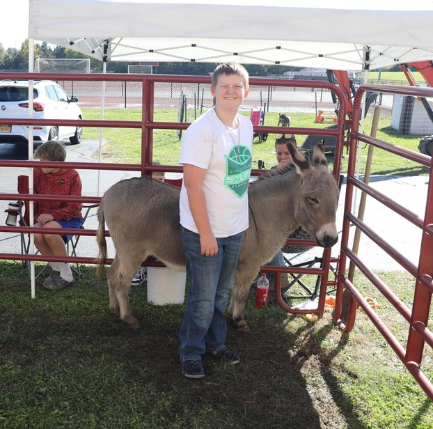 A student poses with Romeo the donkeu