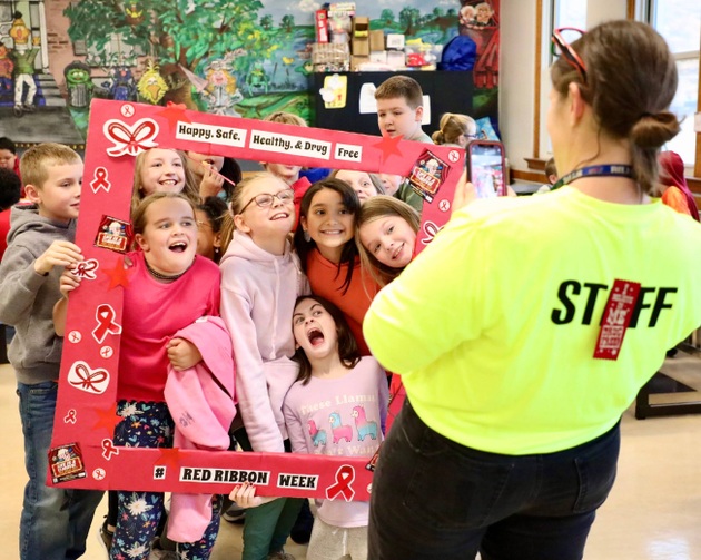 Students stand inside a picture frame for Red Ribbon Week 