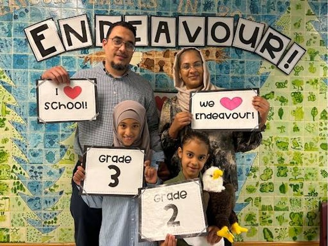 Photo of a family and students holding signs.