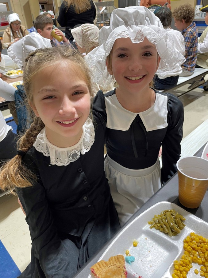 2 students wearing black and white pilgrim costumes